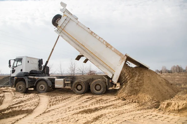 dump truck at work on a construction site. Soil unloading process. Excavation