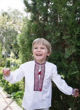 smiling Ukrainian boy 4-5 years old in an embroidered shirt with the emotion of joy on his face. Patriotic education. Symbol of Ukraine, Pride, freedom, independence clipart
