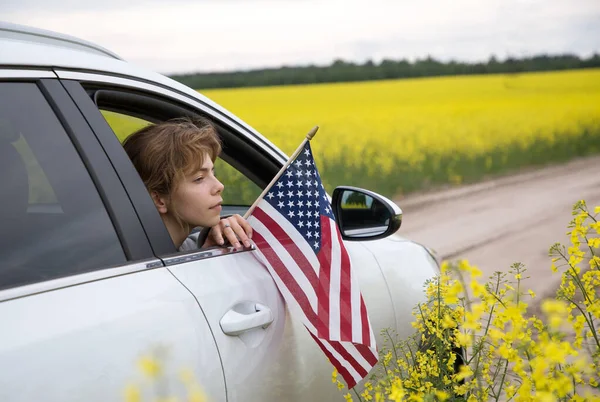 Young Woman American Flag Looks Out Car Window White Car — Foto Stock