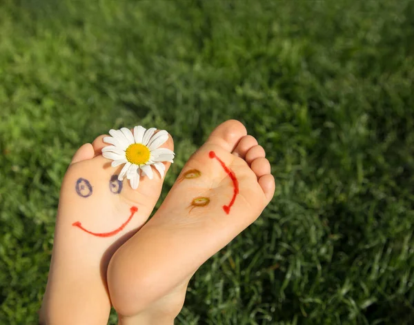 Cute Faces Drawn Bare Feet Child Lying Grass Chamomile Flower — Stock Photo, Image