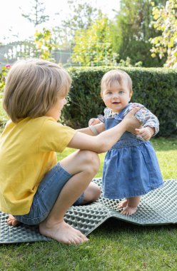İki çocuk, bir ağabey ve bir kız kardeş bahçede birlikte oynuyorlar. Erkek, kız ayaktayken ona destek olur. Yaz yürüyüşleri, bebek bakıcılığı. Çocukluk anları