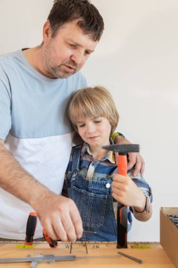 Çocuk ve babası aletlerle çalışmayı ve kendi elleriyle bir şeyler yapmayı öğreniyorlar. Çekiçli bir adam ve çocuk, genç kuşağa deneyim aktararak verimli zaman geçirirler..