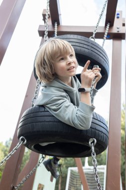 9 yaşındaki bir çocuk açık hava çocuk parkına hevesle tırmanıyor. Çocuklar için sonbahar ya da bahar aktif spor aktiviteleri. Sağlıklı yaşam tarzı, ilginç çocukluk..