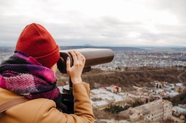 Karlı dağ zirvesinde uçuruma bakan genç bir kadın görüntüsü 