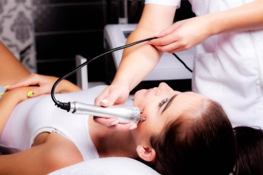 Radyoaktif yüz gerdirme ameliyatı olan kadın. Donanım yüz kozmetolojisi. RF fotoğrafı kaldırıyor.