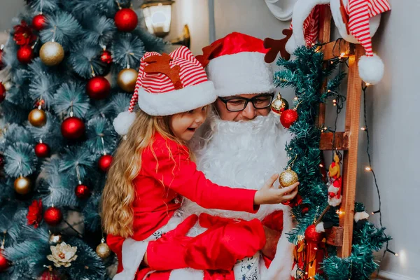 Santa Claus Sosteniendo Linda Chica Delante Del Árbol Navidad — Foto de Stock