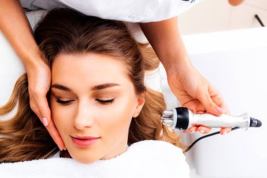 Radyoaktif yüz gerdirme ameliyatı olan kadın. Donanım yüz kozmetolojisi. RF fotoğrafı kaldırıyor.