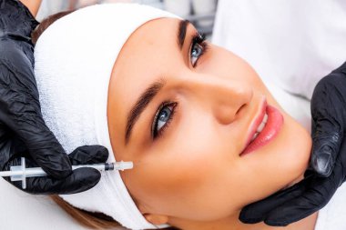 Kozmetik enjeksiyonu. Taklit kırışıklıkların botulinyum toksinle tedavisi. Uyuşturucuyla birlikte şırınga.