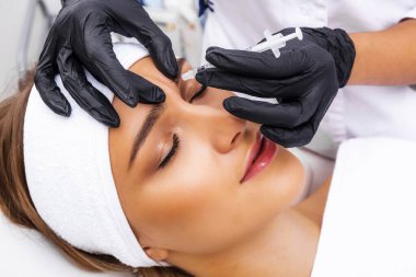 Kozmetik enjeksiyonu. Taklit kırışıklıkların botulinyum toksinle tedavisi. Uyuşturucuyla birlikte şırınga.