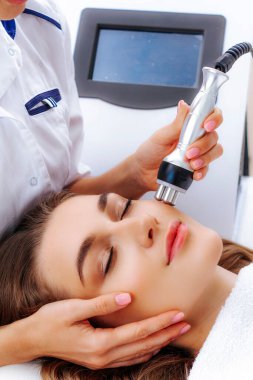 Radyoaktif yüz gerdirme ameliyatı olan kadın. Donanım yüz kozmetolojisi. RF fotoğrafı kaldırıyor.