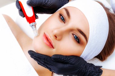 Woman getting Radiofrequency face lifting. Hardware facial cosmetology. RF lifting photo. clipart