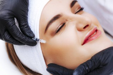 Kozmetik enjeksiyonu. Taklit kırışıklıkların botulinyum toksinle tedavisi. Uyuşturucuyla birlikte şırınga.