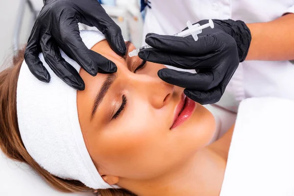 Kozmetik enjeksiyonu. Taklit kırışıklıkların botulinyum toksinle tedavisi. Uyuşturucuyla birlikte şırınga.