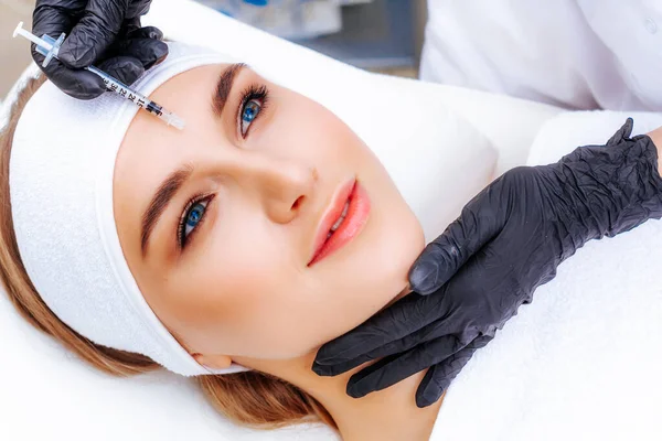 Kozmetik enjeksiyonu. Taklit kırışıklıkların botulinyum toksinle tedavisi. Uyuşturucuyla birlikte şırınga.