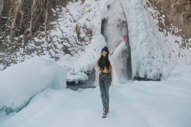 Şelaledeki mutlu kız kışın sevinir. Rusya 'da Dzhily Su Şelalesi.