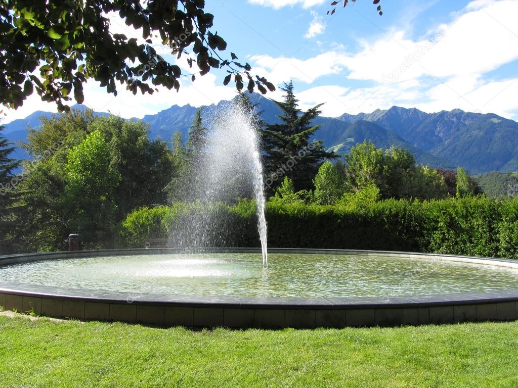 Water fountain with mountain background in a bright sunny day
