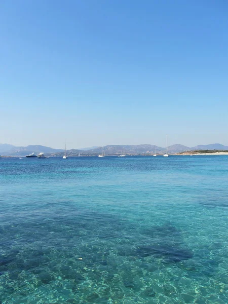 透明な青緑色の海の水と地平線上のボート — ストック写真