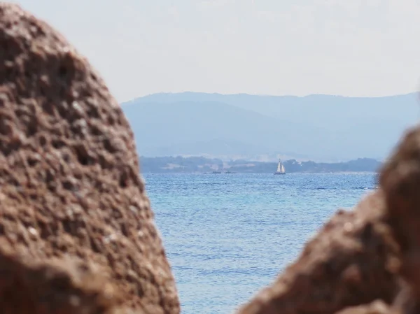 Seascape Tavolara Island på suddig stenar förgrunden — Stockfoto