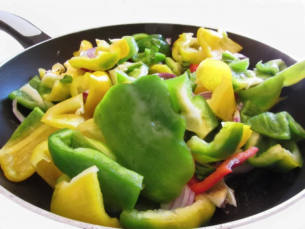 Peppers and onions in the cooking pan on white background — Stock Photo, Image