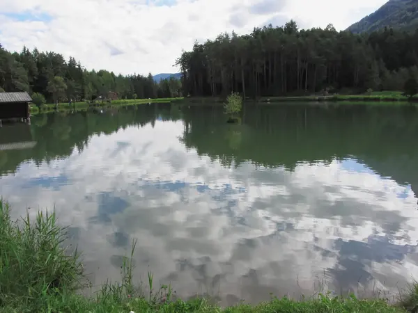 Kis hegyi tó a gondolatok a felhők. Nono allo Bolzanóban, Dél-Tirol, Olaszország — Stock Fotó