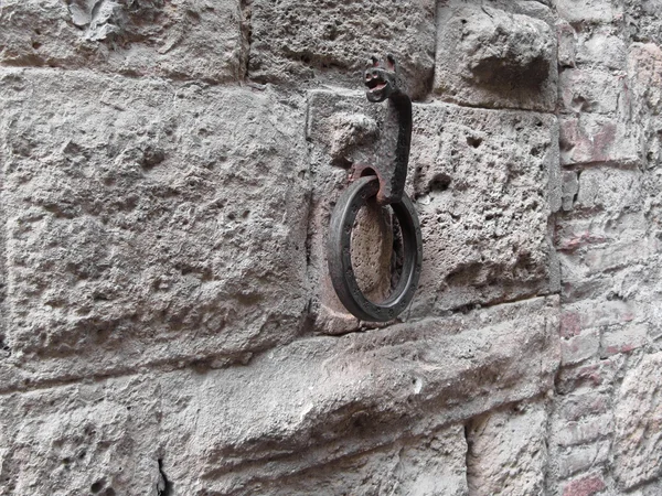 Ancient iron hoop hanging on stone wall — Stock Photo, Image