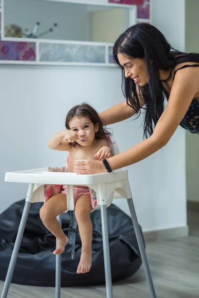 Egy Mosolygó Spanyol Nemzetiségű Anya Joghurtot Etet Egy Kétéves Kislánnyal — Stock Fotó