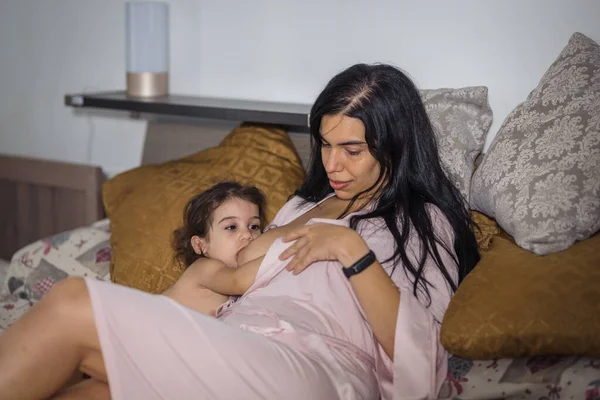 Mãe Latina Amamenta Sua Menina Cama Casal Vestido Rosa — Fotografia de Stock