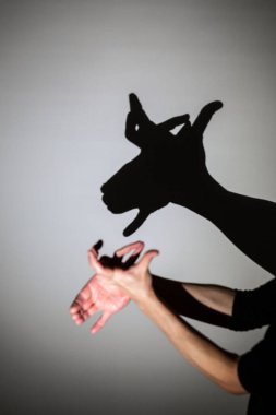 Beyaz ekrana yansıtılan gölgeyi oynat. Beyaz ekrana yansıtılan gölgeyi oynat. Bir insanın elleri ren geyiğini şekillendirir, Rudolph.