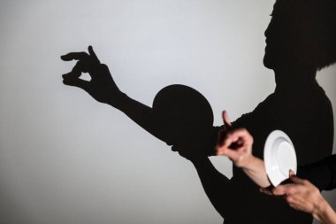 Beyaz ekrana yansıtılan gölgeyi oynat. Bir insanın elleri ve bir tabak bir salyangoz oluşturur.