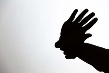 Beyaz ekrana yansıtılan gölgeyi oynat. Bir insanın elleri bir Amerikan yerlisinin kafasını oluşturur.