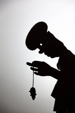 Beyaz ekrana yansıtılan gölgeyi oynat. Bir insanın elleri, elinde fare tutan bir aşçıya şekil verir.