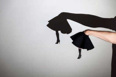 Beyaz ekrana yansıtılan gölgeyi oynat. İnsanın elleri çizmeli bir dansçının bacaklarını şekillendirir.