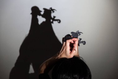 Beyaz ekrana yansıtılan gölgeyi oynat. Elleri konuşan ve öpüşen iki küçük insanı şekillendirir.