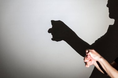 Beyaz ekrana yansıtılan gölgeyi oynat. Kişinin elleri insan yüzüne şekil verir.