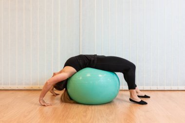 Kız pilates eğitmeni spor salonunda briç egzersizi yapıyor.