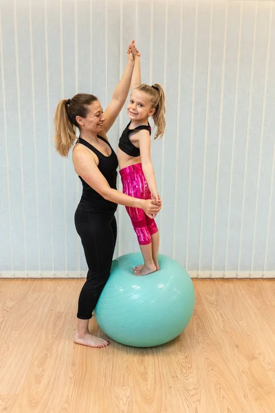 Mãe pilates instrutor e a filha realizar exercícios de equilíbrio fitball — Fotografia de Stock