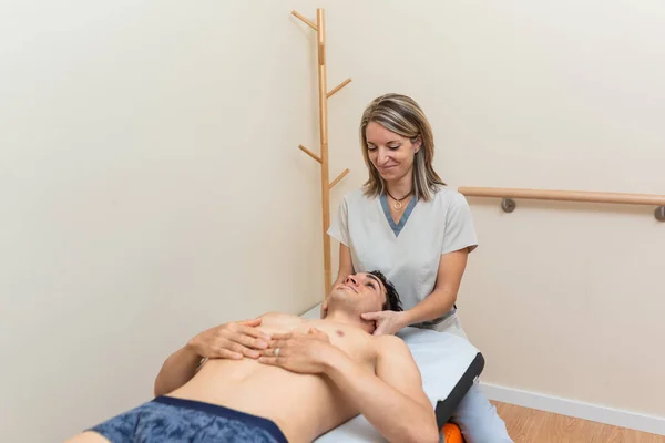 La fisioterapeuta le hace una sesión al hombre. terapia de masaje manual, dolor cervical —  Fotos de Stock