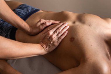 Kadın fizyoterapist erkeğe seans yapıyor. İçsel ostropati