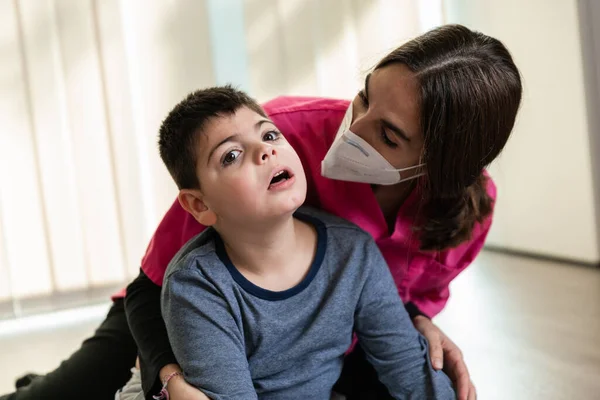 Physiothérapeute travaille avec enfant handicapé, paralysie cérébrale. masque fp2 coronavirus — Photo