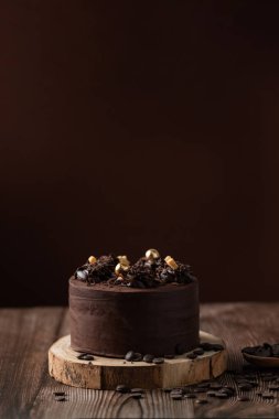 Çikolatalı pastanın önü, çikolata parçacıkları, kaşık ve ahşap masa.