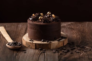 Çikolatalı pastanın önü, çikolata parçacıkları, kaşık ve ahşap masa.