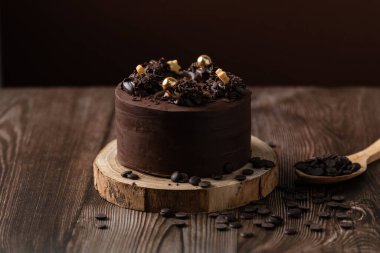 Çikolatalı pastanın önü, çikolata parçacıkları, kaşık ve ahşap masa.