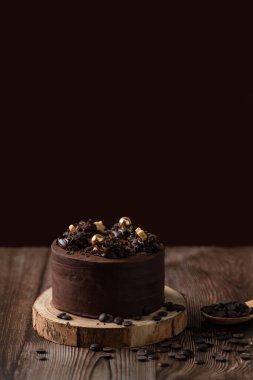 Çikolatalı pastanın önü, çikolata parçacıkları, kaşık ve ahşap masa.