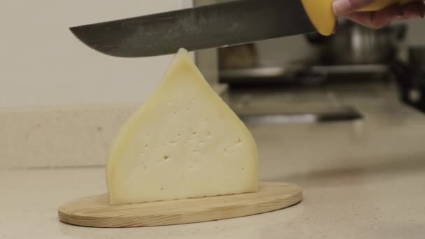 Il formaggio di tetilla galiziano è tagliato con un coltello da mani di donne in una cucina. — Video Stock