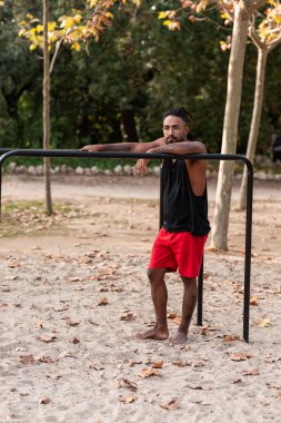Afrikalı Amerikalı sporcu çocuk parktaki barlarda jimnastik yapıyor.
