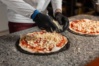 Erkek aşçı İtalyan restoranında pizza hazırlar.