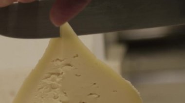 Galiçya tetilla peyniri mutfakta bir kadın eli tarafından bıçakla kesilir..