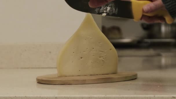 Galiciska tetilla ost skärs med en kniv av en kvinna händer i ett kök. — Stockvideo