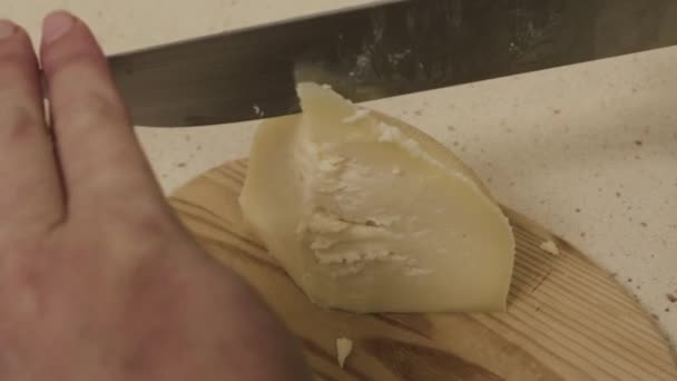Galicische tetilla kaas wordt gesneden met een mes door een vrouw handen in een keuken. — Stockvideo