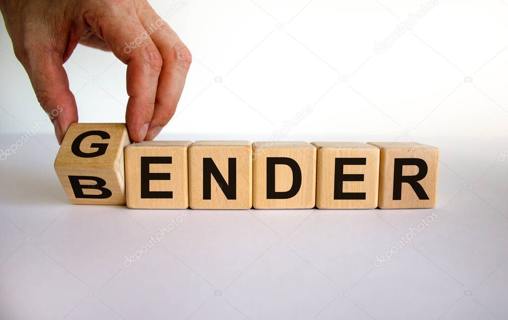 Male hand flips a wooden cube and changes the inscription 'bender' to 'gender' or vice versa. Beautiful white background, copy space. Concept.